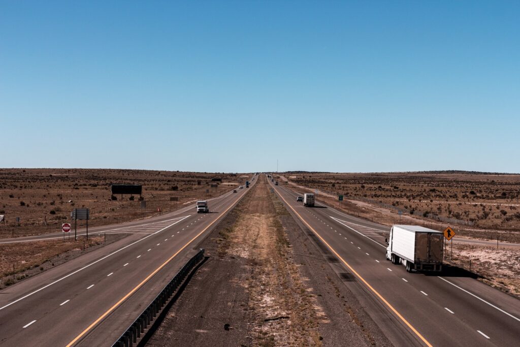 Trucks drive along a stretch of highway. (Jahongir Ismoilov/Unsplash)